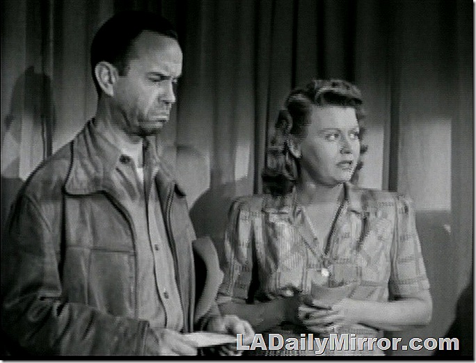 Frowning man in leather jacket and woman in dress with worried expression. 