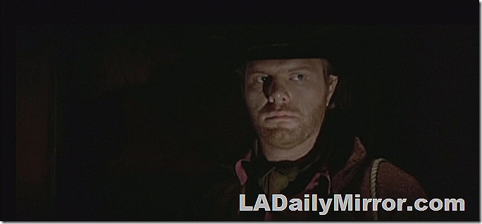 Nighttime scene of man in cowboy hat. 