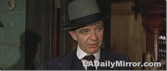 Man in bowler hat, coat and tie. 
