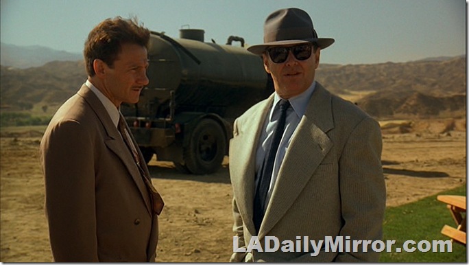 Two men with an oil tanker in the background. 