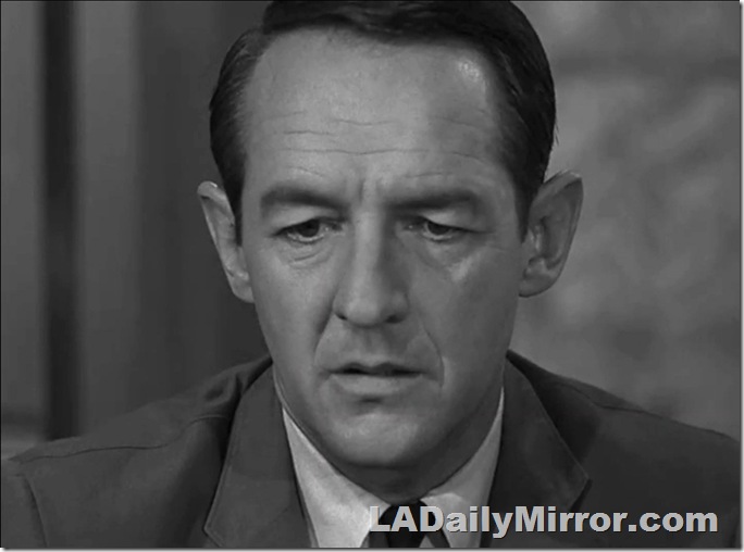 Man in coat and tie with a worried expression. 