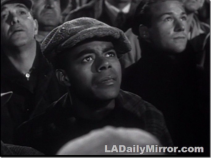 Man wearing a newsboy cap. In a crowd.