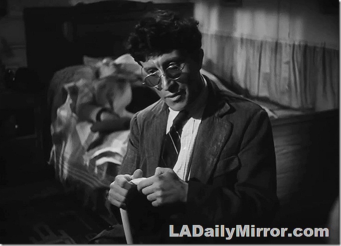 Man with coat and tie, wearing glasses and holding a cane. 