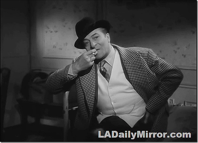 Man in hat and checked coat smoking a cigarette. 