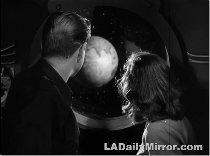 Back of the Head Guy and Back of the Head Woman looking out the portal of a spacecraft. 