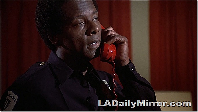 Police officer talking on a red telephone. 