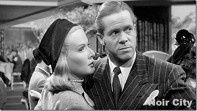 Couple dancing. Dan Duryea wears a double-breasted pinstripe, Junet Vincent wears a hat and pearls. 