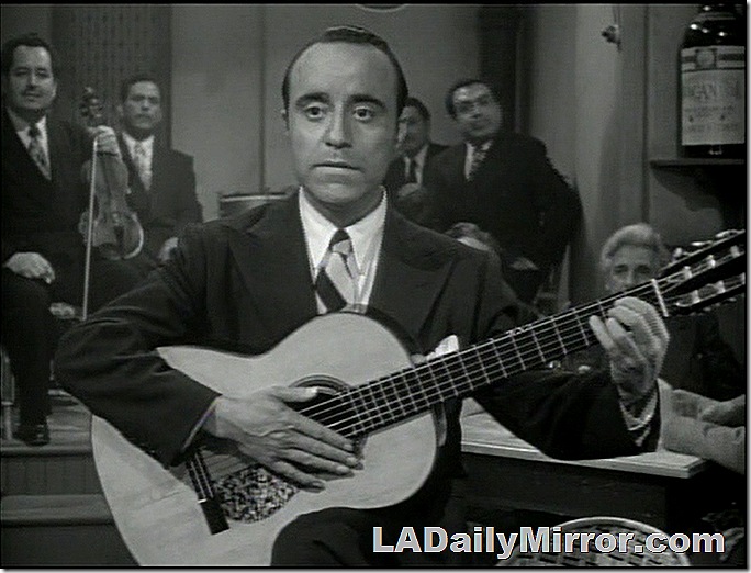 Man in a suit, playing a guitar. Man in a suit, playing a guitar.