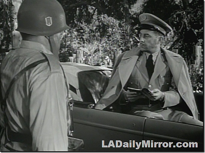 Officer in back of open car. Officer in back of open car.