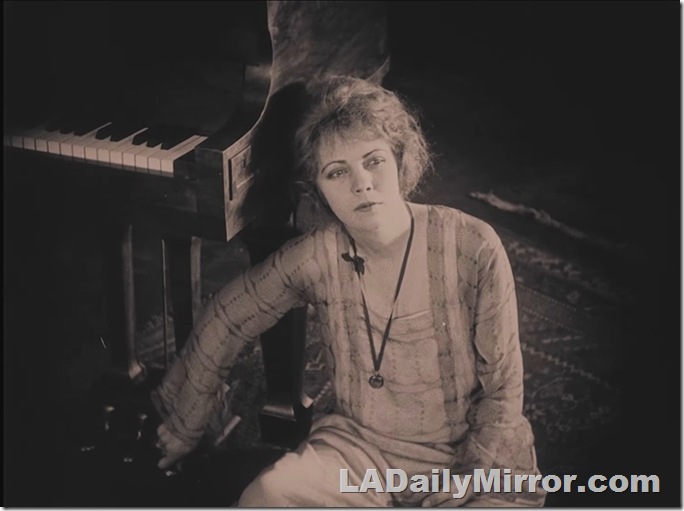 Woman sitting on the floor next to a piano, her hand is on a pedal. Woman sitting on the floor next to a piano, her hand is on a pedal.