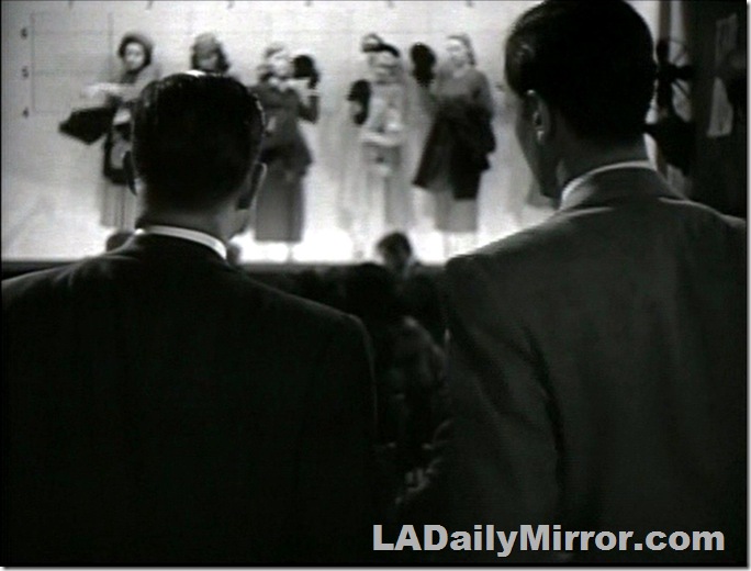 Police lineup of women with two men in suits, their backs to the camera. Police lineup of women with two men in suits, their backs to the camera.