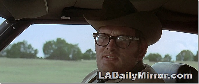 Man riding in a car, wearing glasses and a cowboy hat. Man riding in a car, wearing glasses and a cowboy hat.