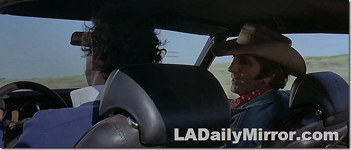 Men riding in a car as seen from the back seat. The man on the right is wearing a cowboy hat and a bandana. Men riding in a car as seen from the back seat. The man on the right is wearing a cowboy hat and a bandana.