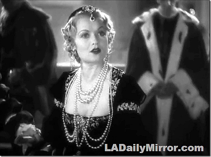 Woman in extravagant gown adorned with jewels. 