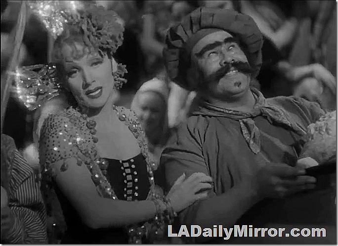 Woman in glittery party dress with mysterious chef with big mustache. 