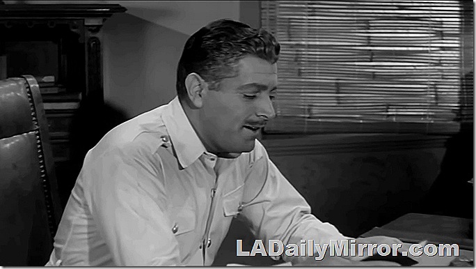 Man with mustache in safari jacket, sitting at a desk. Man with mustache in safari jacket, sitting at a desk.