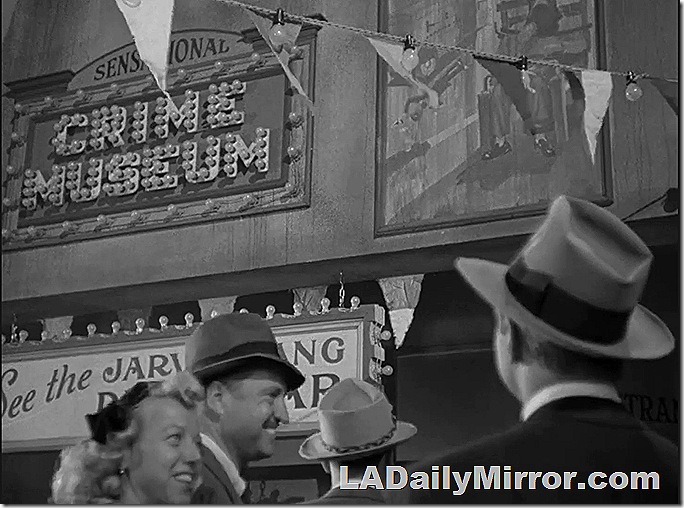 Midway of an amusement park with people in 1940s outfits. 