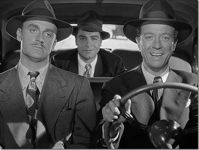 Three men in suits and hats riding in a car. 