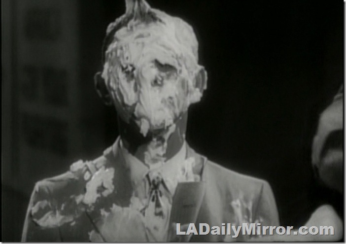 Man in suit, his face covered with glop. 