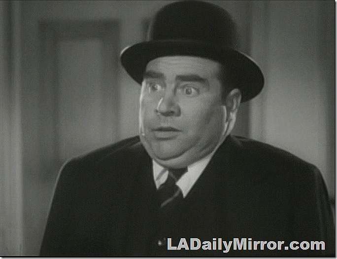 Man in coat, tie and derby with a stunned expression (the man, not the derby). 