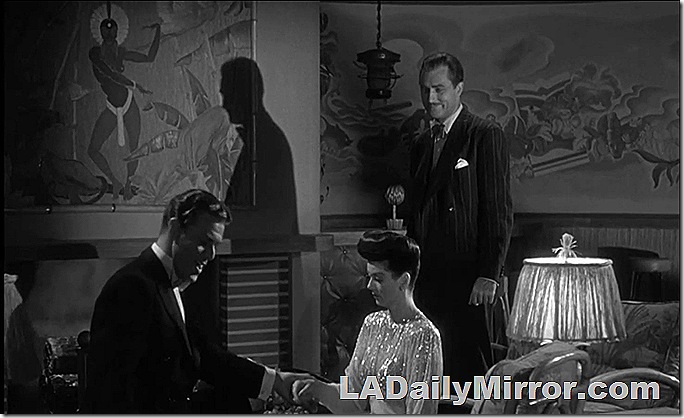 Two men and a woman in a nighttime interior shot. Two men and a woman in a nighttime interior shot.