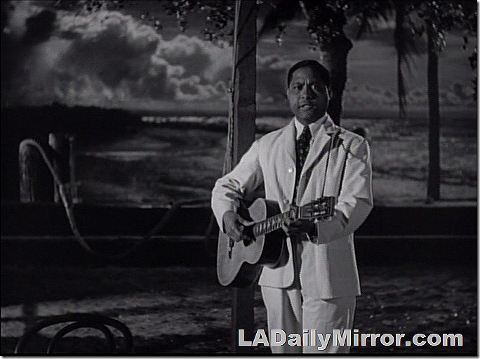 Man in white suit playing a guitar. Man in white suit playing a guitar.